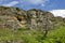 General view toward sedimentary rock with cave in the field