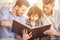 Generation portrait. Grandfather, father and son sitting and reading a book on sofa