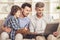 Generation portrait. Grandfather, father and son sitting and using laptop on sofa