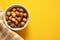 Generative AI Image of Hazelnuts in a Bowl with Blank Space on Yellow Background