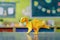 Generative AI Image of Origami Handcraft of Cute Yellow Dinosaur in the Classroom