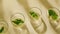 Generative AI Minimal scene of three glass petri dishes containing green tea leaves against the beige background G