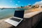 Generic notebook laptop on sunny deserted sandy beach background