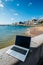Generic notebook laptop on sunny deserted sandy beach background