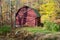 A generic red barn with fall foliage