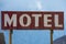 Generic sign for a motel against a cloudy sky