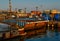 Generic view of industrial harbor with ships, barges with cargo, boats docked. Seascape in sunset