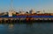 Generic view of industrial harbor, ships, barges with cargo, docked. Seascape in sunset light. Blue sky gradient