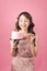 Generous woman holding birthday cake front pink background