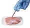 Genetic injection into raw chicken meat on square plate isolated on white background. Genetically modified food and syringe