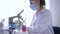Genetically modified plants microscope analysis, expert woman in white coat and gloves examines samples in Experimental