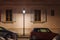 Geneva old-style classical residential building facade with street light and cars parked along the street during summer night,