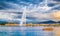 Geneva skyline with famous Jet d`Eau fountain and boat at sunset