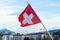 Geneva, Switzerland, April 2020: Flying Swiss flag in a beatuful backdrop of Geneva city