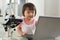 Genius little girl with laptop and microscope