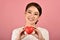 Gentle asian woman holding red heart, Happy smiling girl showing love sign.