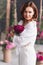 a gentle attractive middle-aged woman in white clothes with a bouquet of peonies