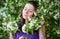 Gentle female portrait in the blooming apple garden.