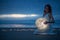 Gentle image of a girl, Astrology, Female magic. Beautiful attractive girl on a night beach with sand hugs the moon, art