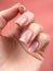 Gentle neat manicure on female hands on a background of dry flowers.