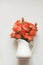 Gentle orange roses in vase on white background. Top view. Floral pattern. Spring concept.