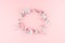 Gentle simple decorative blank wreath of silver branches with copy space on pastel pink background, top view.