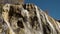 Gentle waterfall on cavernous travertine rock ridge.