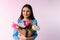 Gentle woman holding a bunch of multicolor tulips on neon pink background with side space for your advertisement