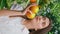 Gentle woman posing oranges at greenery vertical portrait. Girl looking camera