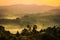 Gentle yellow light and light mist over the hills in country side with traditional houses and the tropical nature of Uganda