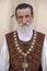 Gentleman with a beautiful gray beard invites tourists to enter the restaurant on the street in city center Lviv, Ukraine