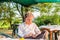 Gentleman using smartphone on a garden chair