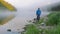 Gentleman watches calm river water with thick morning fog