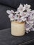 a gently beige wax candle with a hydrangea twig on the sofa rail