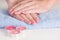 Gently pink gel nails polish on woman hands on blue towel