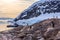 Gentoo penguins gathered on the rocky shore of Neco bay and cruise ship int the bakground, Antarctica