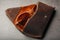 Genuine brown leather glasses case, handmade on a dark background. Glasses inside the case