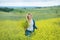 Genuine cute lady woman in meadow of yellow flowers sniffing flower bouquet. Attractive beautiful young girl enjoying the warm sum