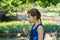 Genuine girl holding a fragile fuzzy dandelion