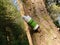 A geocache cylindrical container hanging on a broken branch from a tree trunk while hiking a forest