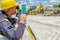 Geodesist is working with total station on a building site. Civil engineer with theodolite equipment during surveyor work.