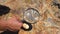 Geologist hand examines rock crystals mineral under magnifying glass