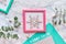 Geometric Christmas flat lay top view with pink and green frames and green paper. Fresh eucalyptus twigs and decorative white