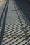 Geometric diagonal shadow from an  fence on a path from paving slabs. Background from light and shadow.