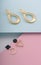 Geometric and infinity shape golden earrings on pastel colors paper background