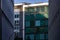 Geometric patterns of modern corporate buildings with concrete walls and square windows closed by striped shutters