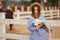 Georgeus woman stand in front of farm and hold a bouquet of flower in hands. Beautuful bouquet. Woman in blue dress and