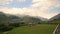 Georgia. Orchard amid high mountains. Summertime stormy sky. Picturesque mountain village.