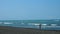 Georgia, Ureki - June 2019: child stands on the black sand on the shore and looks at the sea