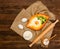 Georgian cuisine. Khachapuri with eggs on sackcloth, salt, flour, eggs and parsley on a wooden table